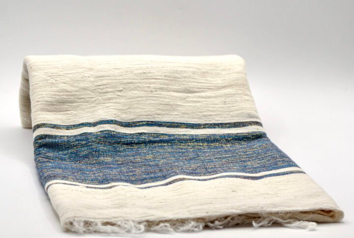 Yabsra Scarf in Azure — handwoven Ethiopian cotton scarf featuring soft cream tones with blue and teal woven stripes.