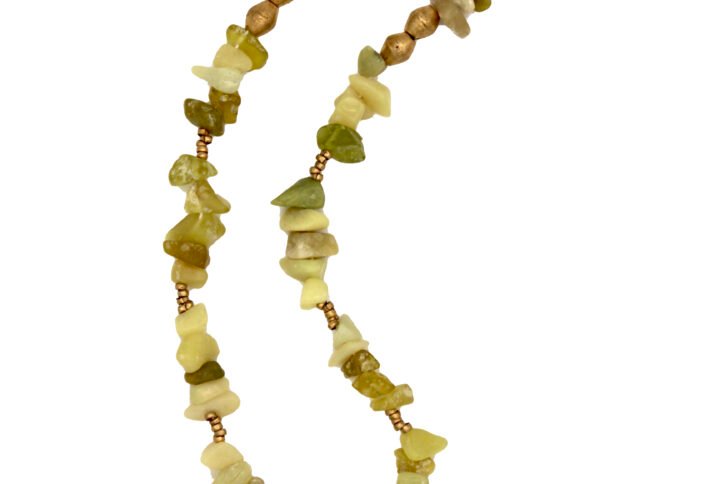 Handcrafted Ethiopian necklace featuring raw peridot crystal beads with an antique amulet pendant symbolizing protection and renewal.