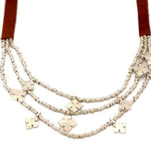 Triple-strand silver necklace featuring hand-cut metal amulets on a rich brown leather strap, handcrafted in Ethiopia.